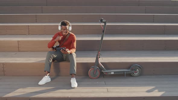 Cheerful African American Man Watching Music Videos Outdoors