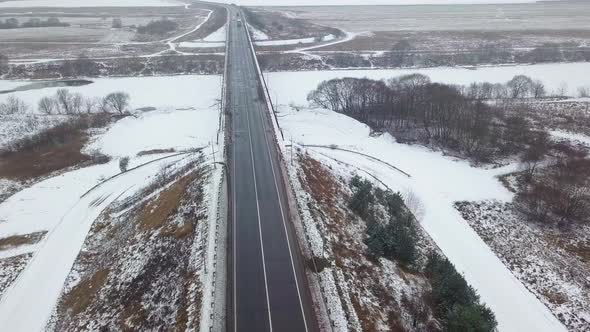 Winter highway, car and truck traffic. On the sides of the forest.