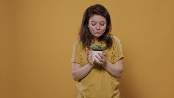 Portrait of Woman Hugging Potted Decoration Plant Admiring Kissing and Petting Green Leaves