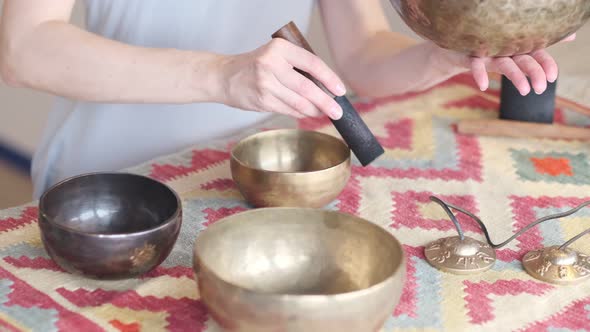 Woman Playing on Tibetan Singing Bowl While Sitting on Yoga Mat