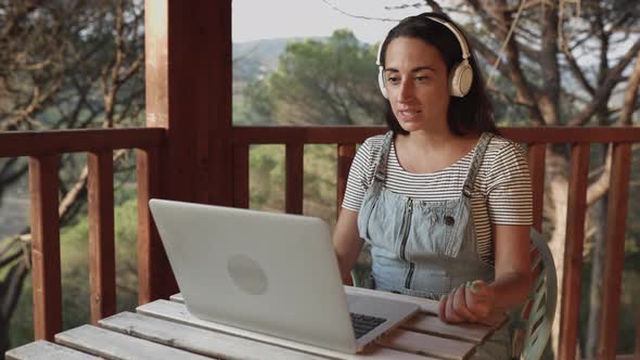 Hispanic Woman Using Laptop Computer for Video Call at Home Terrace