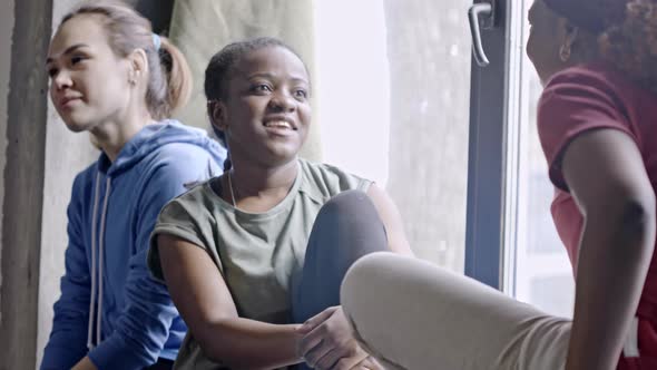 Black Women Chatting on Windowsill