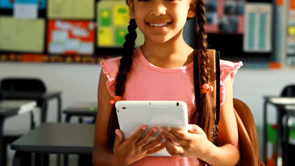 Schoolgirl holding digital tablet in classroom 4k