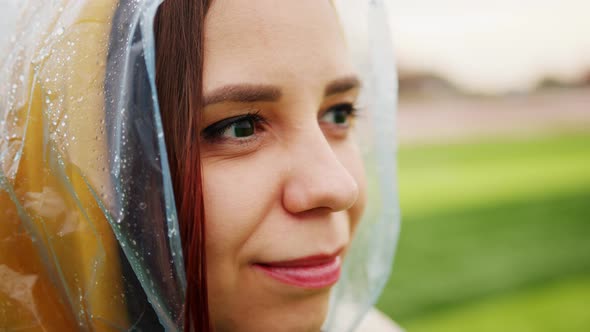 Young Woman in Raincoat in Rainy Weather