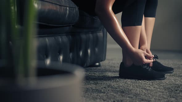 Woman Ties Her Shoes Before Starting Workout at Home or Gym. Active Woman Tying Up Shoelaces During
