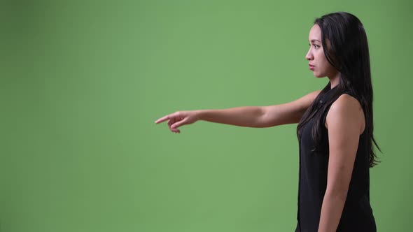 Profile View of Young Beautiful Asian Businesswoman Pointing Finger