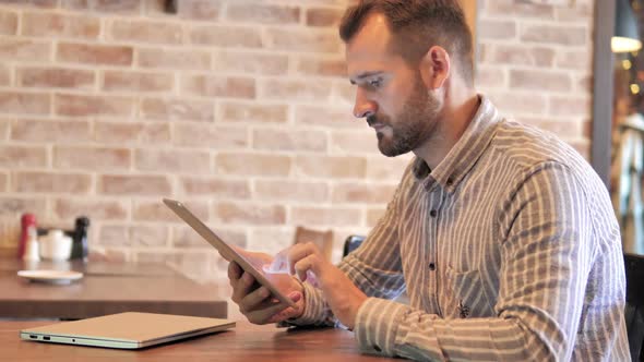 Beard Casual Man Using Tablet While Sitting Outdoor