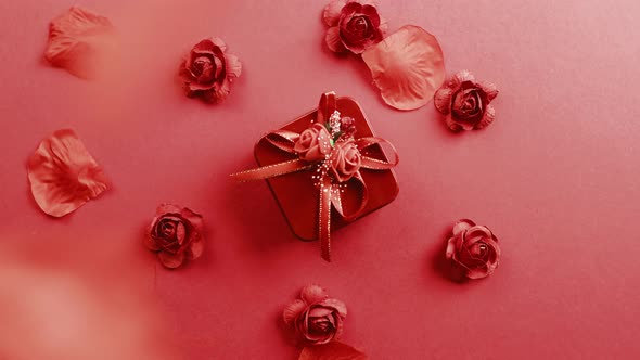 Red Gift with Petals Falling Down on the Background