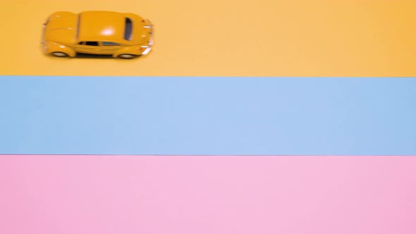 Small Vintage Retro Toy Cars on a Pink Yellow Blue Background