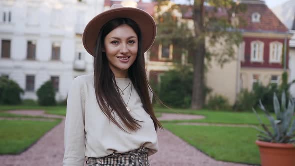 Joyful Woman in Lovely Hat Posing on Camera During Her Walk