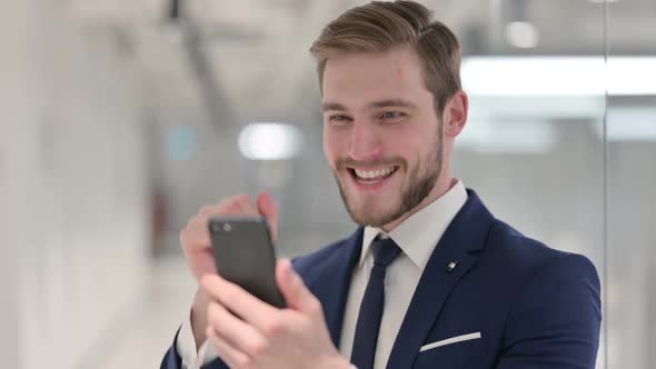 Young Businessman Celebrating on Smartphone