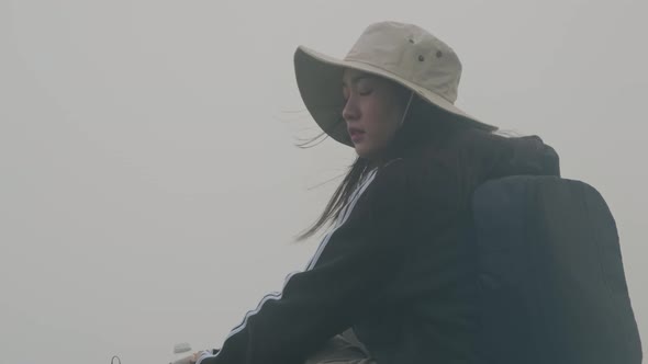 Young female tourist enjoying the view and the beautiful sea of mist on the mountain.