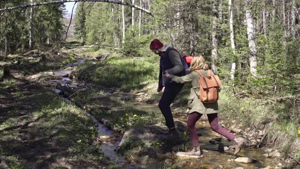 Young Couple Stepping over Little Brook
