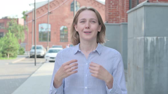 Woman Talking on Online Video Call While Walking in Street