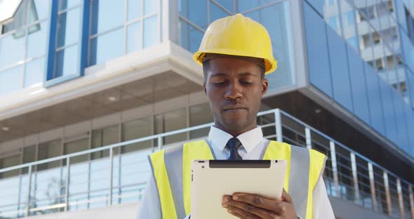 Business Architect Man Wearing Hardhat and West Standing Outdoors of Building Using Digital Tablet