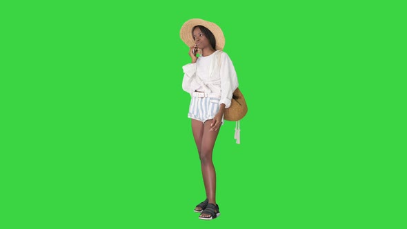 Pretty Young African American Woman in a Straw Hat Talking on Her Phone on a Green Screen, Chroma