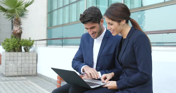 Business people working on laptop computer together