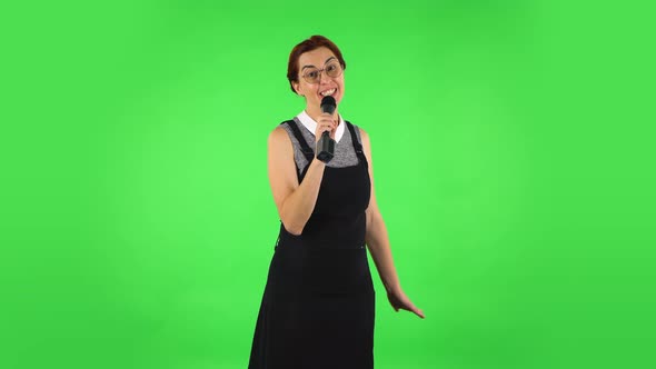 Funny Girl in Round Glasses Is Singing Into a Microphone and Moving To the Beat of Music. Green