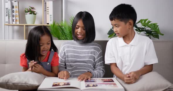 Three kids reading a book.