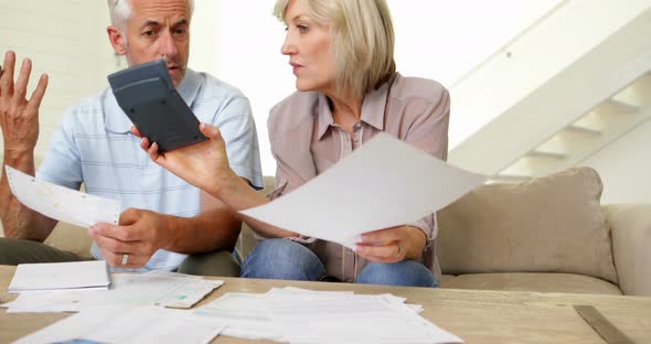 Stressed Couple Working out their Bills on the Couch