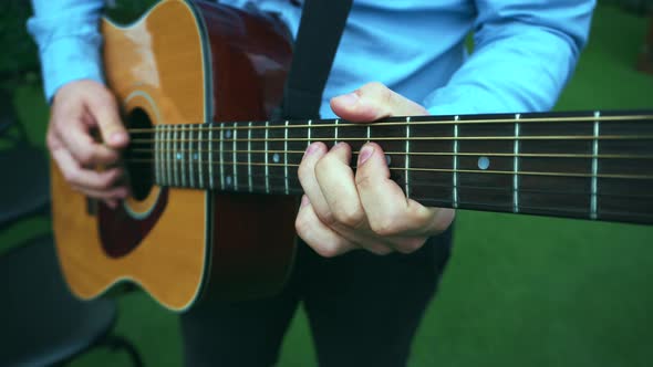 Man playing at guitar at wedding ceremony outdoor