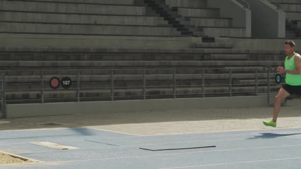 Close up view of caucasian athlete doing long jump