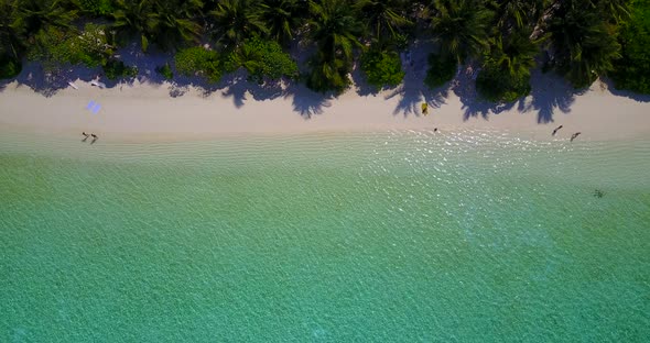 Natural fly over abstract shot of a sandy white paradise beach and aqua blue water background in 4K