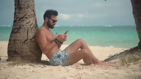 Man On Vacation.Tanned Man Relaxing Vacation Caribbean Tropical Beach.Summer Sunbathing On Resort.