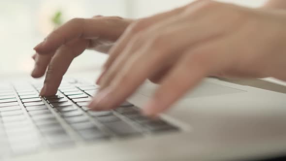 Hands Typing on Laptop Keyboard