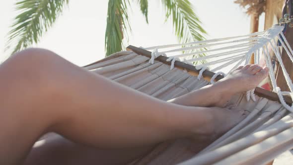 Focus on Caucasian woman enjoying the hammock at beach