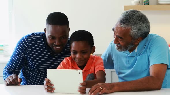 Family using digital tablet in kitchen