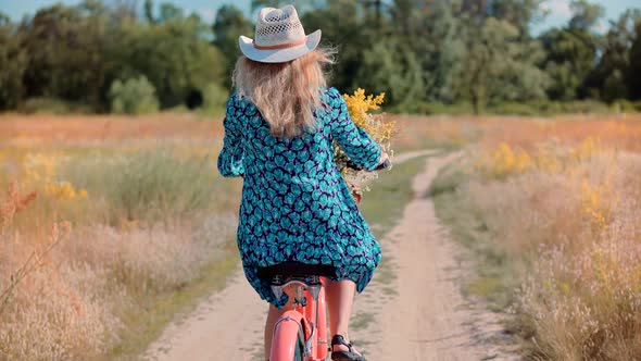 Woman Cyclist Riding On Bicycle And Having Fun. Woman In Hat Enjoying Summer. Bike With Basket.