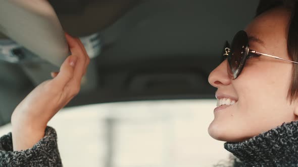 Gorgeous Caucasian Woman with Brown Hair and Toothy Smile Sitting in a Car