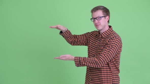 Happy Young Hipster Man Snapping Fingers and Showing Something