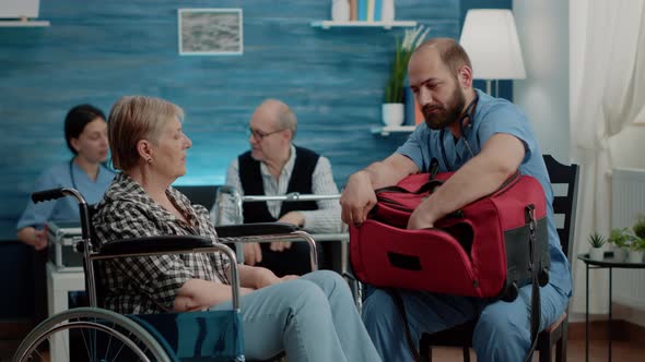 Medical Assistant Checking Temperature of Disabled Woman