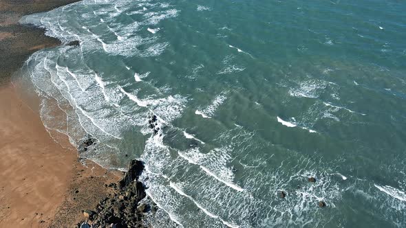 Stone beach and waves aerial shot