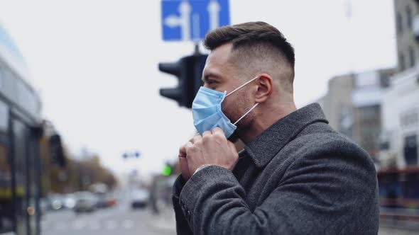 Man wearing face masks during coronavirus outbreak. Young man walking down the street wearing mask 