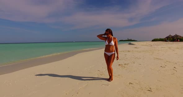 Beautiful beauty model on vacation spending quality time at the beach on paradise white sand and blue