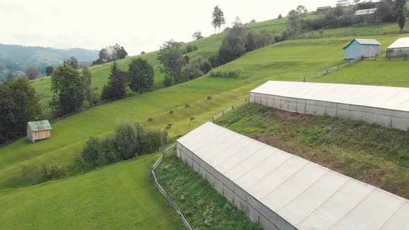 Landscape View of Greenhouses on Meadows in Mountains