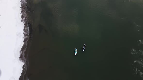 Two People Kayak on the Winter River