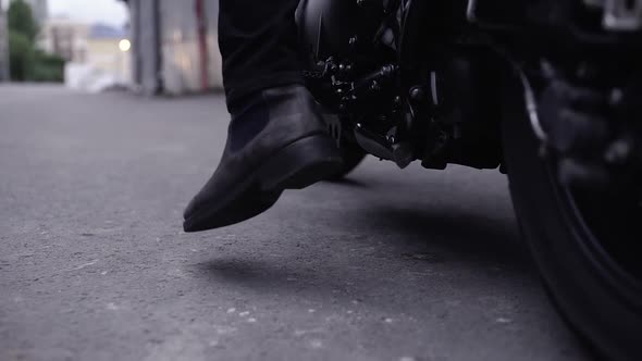 Biker man sitting on his motorcycle before driving it, close up of a motorbike, masculine and fashin