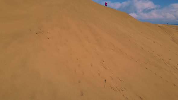 Man on sand dunes by the sea