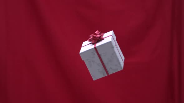 Christmas present tossed into the air red background
