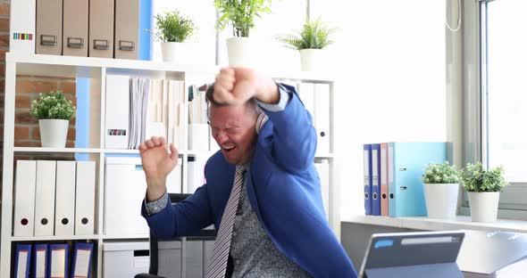 Joyful Man Dancing with Headphones in Workplace
