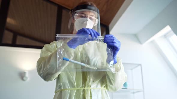 Healthcare worker putting nasal swab in plastic bag