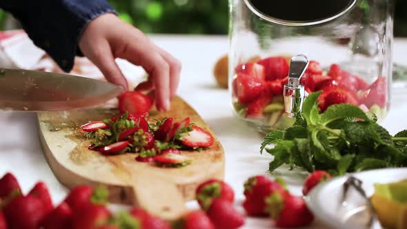 Step by step. Slicing fresh organic fruits for infused water.