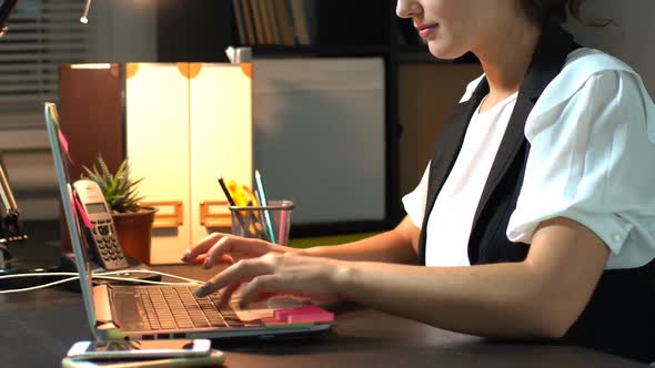 Businesswoman Sitting At Her Workplace In Office And Working At Laptop