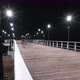 Time Lapse of People Walking on a Sea or Ocean Wooden Pier by the Beach at Night - VideoHive Item for Sale