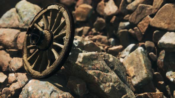 Old Wooden Wheel on Rocks alt
