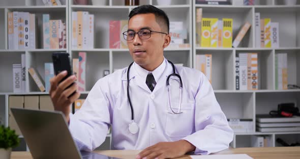 Doctor making conference call on smartphone